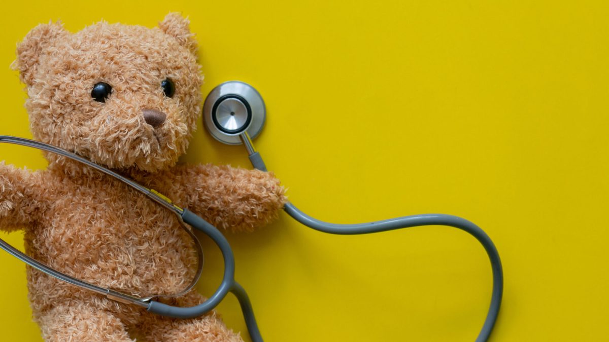 Teddy bear with stethoscope on yellow. Pediatric surgery