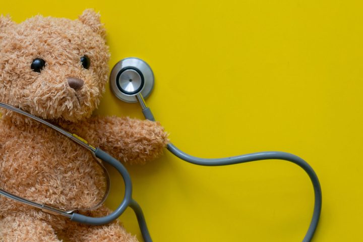 Teddy bear with stethoscope on yellow. Pediatric surgery