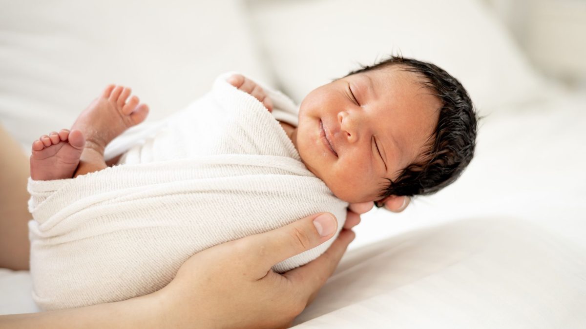 Infant wrapped in a blanket waiting for their infant circumcision