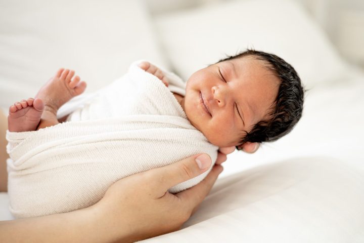 Infant wrapped in a blanket waiting for their infant circumcision